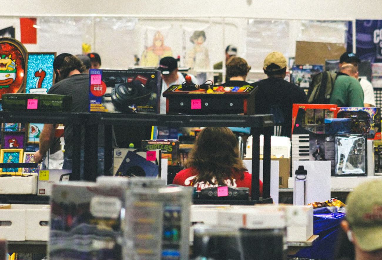Collectors browsing vendor tables at a busy card and collectibles show